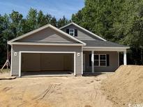 Charming home exterior with gray siding, a spacious garage, and a covered front porch; perfect curb appeal at 1397 Knotty Branch Rd., Conway, SC 29527