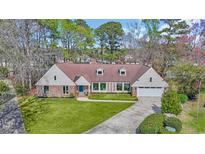 Charming home featuring a well-manicured lawn and a brick facade, complemented by a bright blue front door at 1625 Deer Park Ln., Surfside Beach, SC 29575