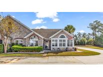 Charming stone and beige home with an American flag and manicured landscaping at 109 Stonegate Blvd. # 109, Murrells Inlet, SC 29576