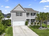 Inviting two-story home with a charming balcony, attached garage, and a well-manicured front yard at 1101 Bronwyn Circle, North Myrtle Beach, SC 29582