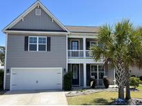 Charming two-story home featuring a balcony, well-maintained lawn, and an attached two-car garage at 1101 Bronwyn Circle, North Myrtle Beach, SC 29582