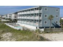 Coastal condo complex featuring multiple floors with white balconies, pool, and beach access at 116 S Waccamaw Dr. # 201, Garden City Beach, SC 29576