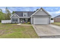 Charming one-story home featuring gray siding, a well-manicured lawn, and an attached two-car garage at 1794 Graham Rd., Aynor, SC 29544
