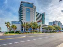 View of Compass Cove Resort featuring a tall building with blue accents and a compass design near a street and palm trees at 2311 S Ocean Blvd. # 144, Myrtle Beach, SC 29577