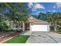Charming single-story home featuring a two-car garage, front porch and well-manicured lawn at 320 Cog Hill Ct., Murrells Inlet, SC 29576