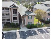 Beautiful condo building with two-story access stairs, lush landscaping, and ample parking at 524 Pinehurst Ln. # 19D, Pawleys Island, SC 29585