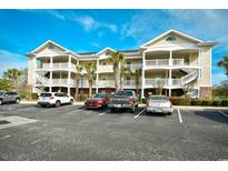Condominium complex featuring multi-level balconies, mature landscaping, and ample parking at 5801 Oyster Catcher Dr. # 332, North Myrtle Beach, SC 29582