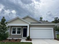 Charming single-story home with neutral siding, a two-car garage, and freshly landscaped front yard at 615 Muster Field Ct., Conway, SC 29526