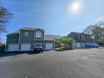 Attractive two-story exterior with individual garages and a blue car parked in the parking lot at 800 Castleford Circle # 1-E, Myrtle Beach, SC 29572
