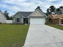 Charming single-story home boasts a gray roof, a well-manicured lawn, and a two-car garage at 933 Padgett Lane, Conway, SC 29526