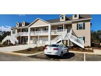 Charming two-story condo building with inviting staircases and well-maintained landscaping under a clear blue sky at 1411 Gooseneck Place # 202 Middle, Murrells Inlet, SC 29576