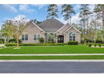 Beautifully landscaped, single story, brick home with a well manicured lawn and mature landscaping at 152 Creek Harbour Circle, Murrells Inlet, SC 29576