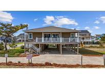 Two-story beach house with a large deck and covered parking underneath the house, inviting coastal charm at 202 56Th Ave. N, North Myrtle Beach, SC 29582