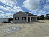 New construction home with gray siding, black shutters, and a covered entryway at 334 William Nobles Rd., Aynor, SC 29511