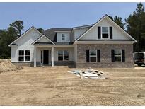Two-story home with a brick facade, white siding, black shutters and an unfinished front yard at 346 Ridge Rd., Galivants Ferry, SC 29544
