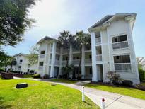 A bright, multi-story building with white siding, multiple balconies, and well-kept landscaping at 569 Blue River Ct. # 9-A, Myrtle Beach, SC 29579