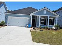 Charming single-story home showcasing a well-manicured lawn, two-car garage, and covered front entry at 1800 Sunshine Ct., North Myrtle Beach, SC 29582