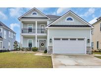Charming two-story home featuring a two-car garage and covered porch with decorative wreath on the front door at 186 Palmetto Harbour Dr., North Myrtle Beach, SC 29582