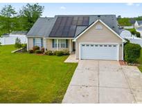 Charming single-story home featuring a well-manicured lawn and solar panels for energy efficiency at 601 Seth Ln., Longs, SC 29568