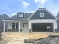 Charming single-story home with a two-car garage, stone accents, and light gray siding at 1105 Nw Forest Bend Dr., Calabash, NC 28467