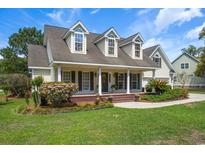 Charming traditional-style home with a welcoming front porch, dormer windows, and a beautifully landscaped front yard at 120 Wraggs Ferry Rd., Georgetown, SC 29440