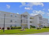 Attractive condominium building featuring screen enclosed balconies and manicured landscaping at 1950 Bent Grass Dr. # K, Surfside Beach, SC 29575