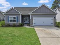 Charming single-story home featuring a two-car garage, landscaped lawn, and a welcoming entrance at 200 Palm Terrace Loop, Conway, SC 29526