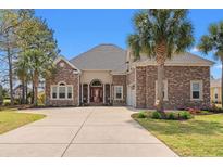 Charming single-Gathering home with brick exterior, manicured lawn, and a spacious driveway with palm trees at 2039 Woodburn Dr., Myrtle Beach, SC 29579