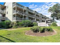 Charming condo building with multiple floors and lovely landscaping around the complex's sign at 212 Maison Dr. # M 303, Myrtle Beach, SC 29572