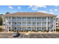 Three-story condo building with ample parking and exterior stairs to each unit at 4679 Wild Iris Dr. # 103, Myrtle Beach, SC 29577