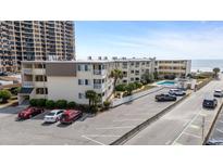View of an attractive condo complex with a swimming pool and ample parking at 9620 Shore Dr. # 307, Myrtle Beach, SC 29572