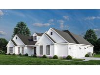 Charming white farmhouse-style home with a well-manicured lawn and a three-car garage at 974 Crooked Oak Dr., Pawleys Island, SC 29585