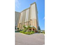 Stunning high-rise condo building boasts beautiful landscaping and inviting entrance on a sunny day at 9994 Beach Club Dr. # 408, Myrtle Beach, SC 29572