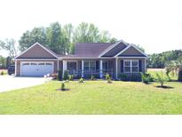 Charming single-story home with a well-manicured lawn and attached two-car garage at 1210 Horry Rd., Aynor, SC 29511