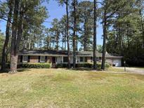 Charming single story brick home featuring mature trees, manicured landscaping, and an attached two car garage at 106 Jessamine St., Andrews, SC 29510