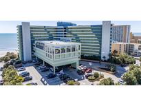Oceanfront condo building featuring a parking garage and beach access at 1105 S Ocean Blvd. # 422, Myrtle Beach, SC 29577
