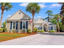 Charming single-story home with manicured landscaping, palm trees, and a concrete driveway under a sunny sky at 141 Wickham Ct., Pawleys Island, SC 29585