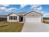 Charming single-story home featuring a two-car garage, tidy lawn, and attractive gray siding at 1446 Nokota Dr., Conway, SC 29526