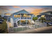 Charming two-story beach home with a white picket fence and spacious covered porch, perfect for coastal living and entertaining at 1512 S Ocean Blvd., North Myrtle Beach, SC 29582