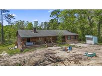 Charming cabin-style home featuring a cozy front porch and rustic wood siding surrounded by lush greenery at 1651 Weldon Ln., Conway, SC 29526