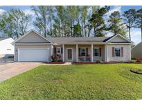 Charming single-story home featuring a well-manicured lawn, neutral siding, and a welcoming covered porch with rocking chairs at 180 Oak Crest Circle, Longs, SC 29568