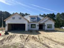 Under-construction exterior showing open garage and newly installed roof sheathing on a bright, sunny day at 204 Shady Pines Ct., Conway, SC 29527