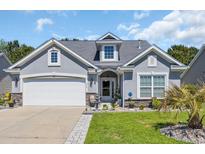 Charming single-story home featuring a stone-accented facade, well-manicured lawn, and a two-car garage at 254 Tall Palms Way, Little River, SC 29566