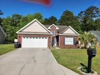 Charming single-story brick home featuring a well-manicured lawn and attached two-car garage at 328 Harbour Reef Dr., Myrtle Beach, SC 29588
