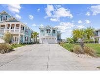 Charming, light blue two-story home with an attached two-car garage and a concrete driveway at 422 Harbour View Dr., Myrtle Beach, SC 29579