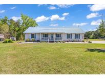 Charming one-story home with a large front yard and a quaint, covered front porch at 5086 Highway 319 E, Conway, SC 29526