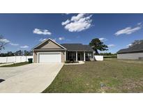 Charming single-story home with attached garage, complemented by a well-manicured lawn and lovely landscaping at 6392 Highway 378, Conway, SC 29527