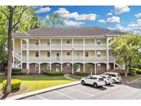 Inviting condo exterior features balconies, manicured lawn, and ample parking at 679 Riverwalk Dr. # 201, Myrtle Beach, SC 29579