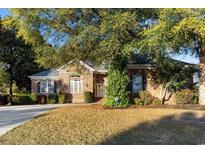Charming brick home featuring a manicured lawn and lush greenery, creating an inviting curb appeal at 808 East Coast Ln., North Myrtle Beach, SC 29582