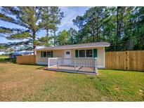 Charming home featuring a cozy front deck, green shutters, and a well-maintained lawn at 2939 King St., Loris, SC 29569